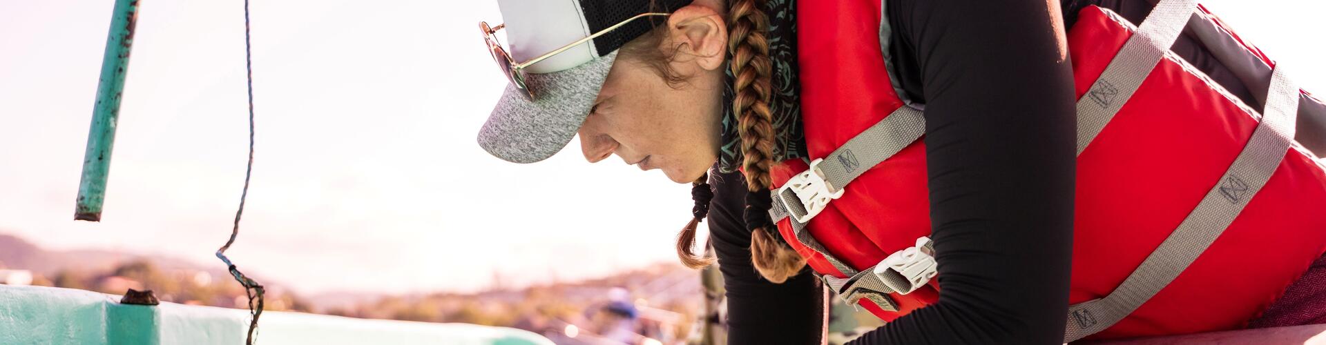 marine biologist in life jacket, on a yacht, making notes